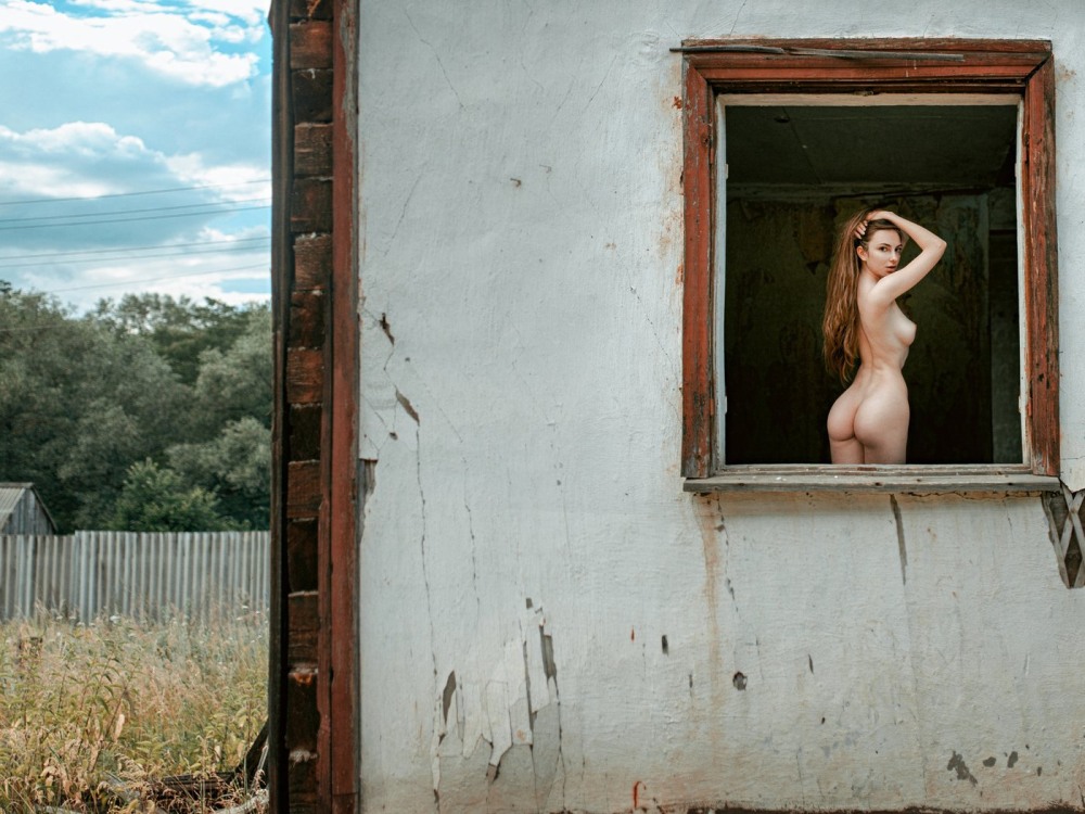 Девушка раздевается в окне