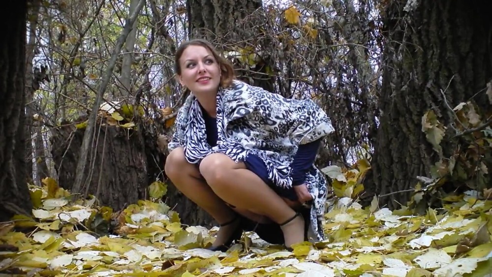 Женщина присела в кустах